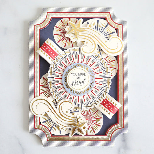3 dimensional card with raised frame, firework embellishments, stars and You Make Me Proud sentiment