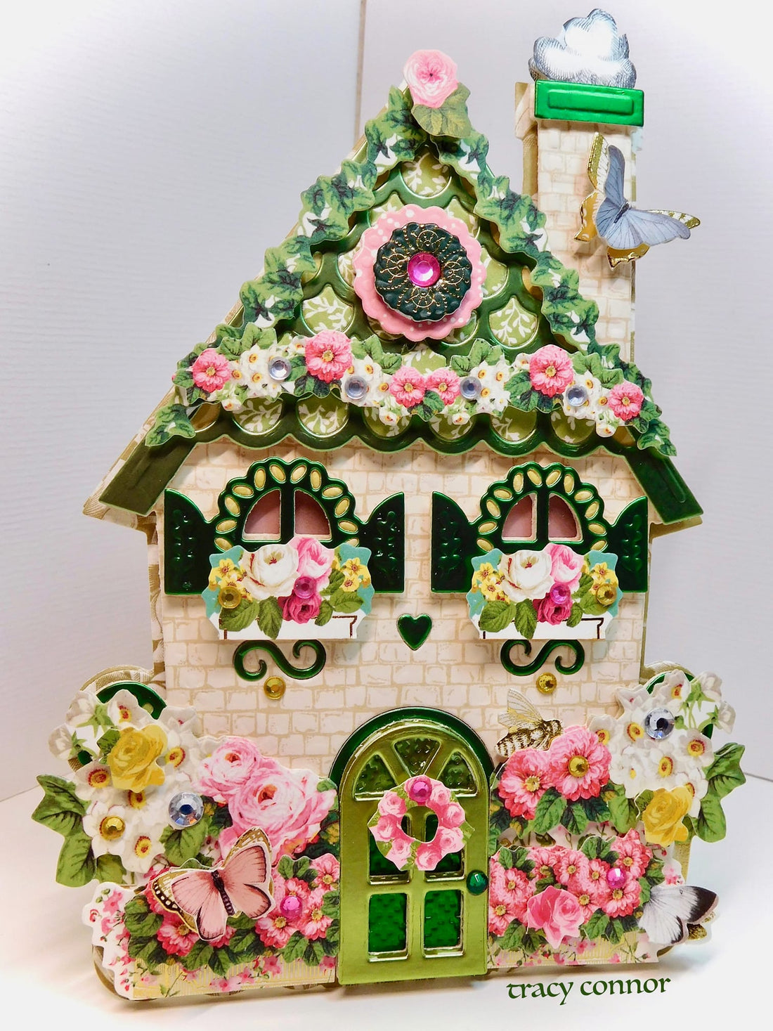 a small house with a green door and flowers on it.