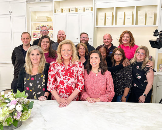 a group of people standing around a table in a kitchen.