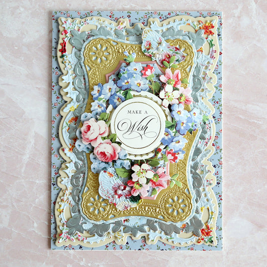 A blue and gold wedding card with flowers on it.