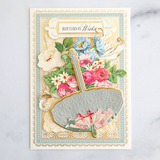 ivory card with blue border with embossed layer, inlayed umbrella and collages of flowers with a Birthday Wishes sentiment
