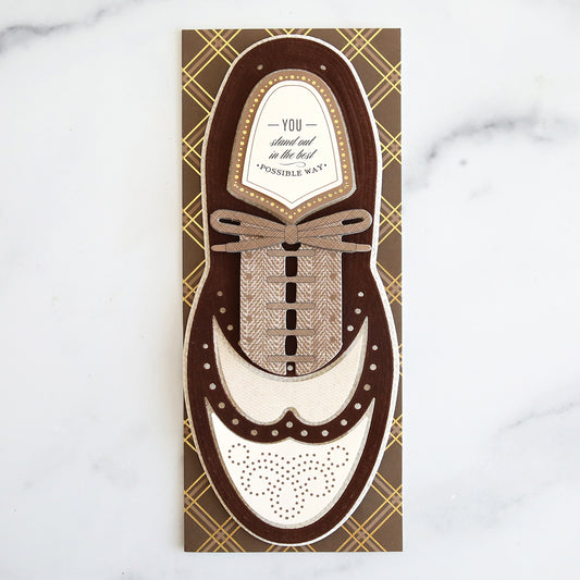 Brown plaid slimline card with brown and cream textured wingtip shoe.