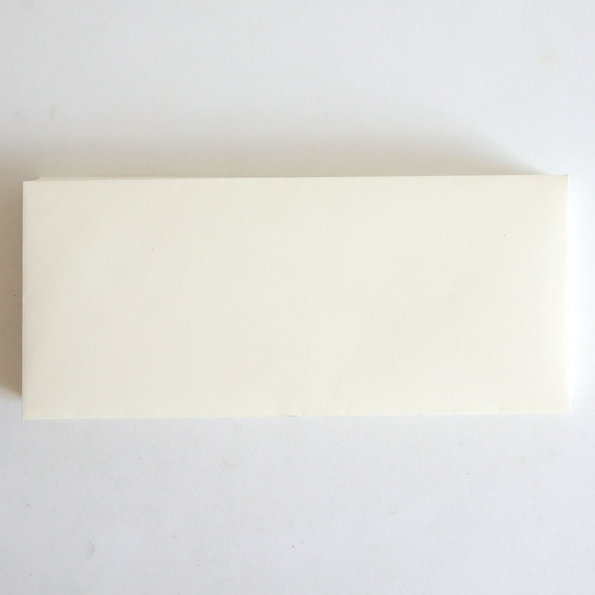 A 25 Pack of Natural Envelopes (4.125" x 9.5") rests on a white surface, its simple rectangular design reminiscent of Classic Crest envelopes.