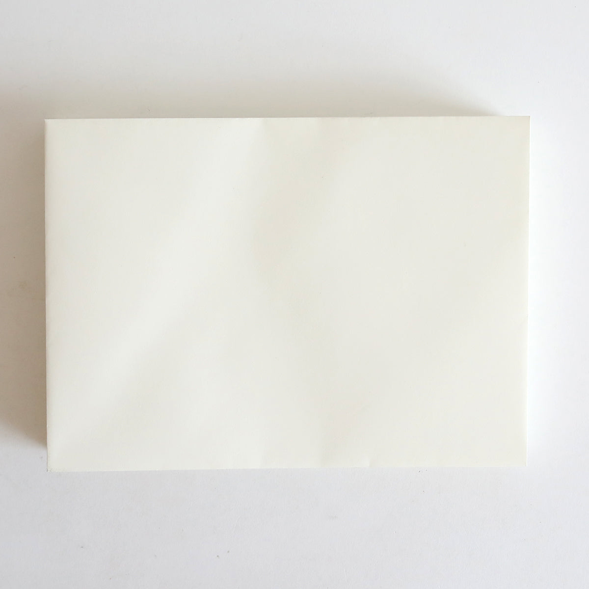 A 25 Pack of Natural Envelopes, each measuring 5.25" x 7.25", displayed on a white surface for a crisp, elegant look reminiscent of invitation envelopes.