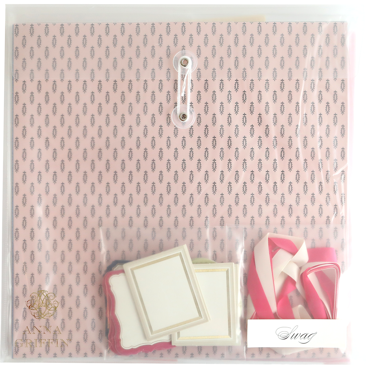 The Crop at Home 3 Swag stationery set, ideal for scrapbooking or cardmaking, comes in a pink pattern and includes various colored labels and ribbons, all secured with a closure string in a transparent plastic cover.