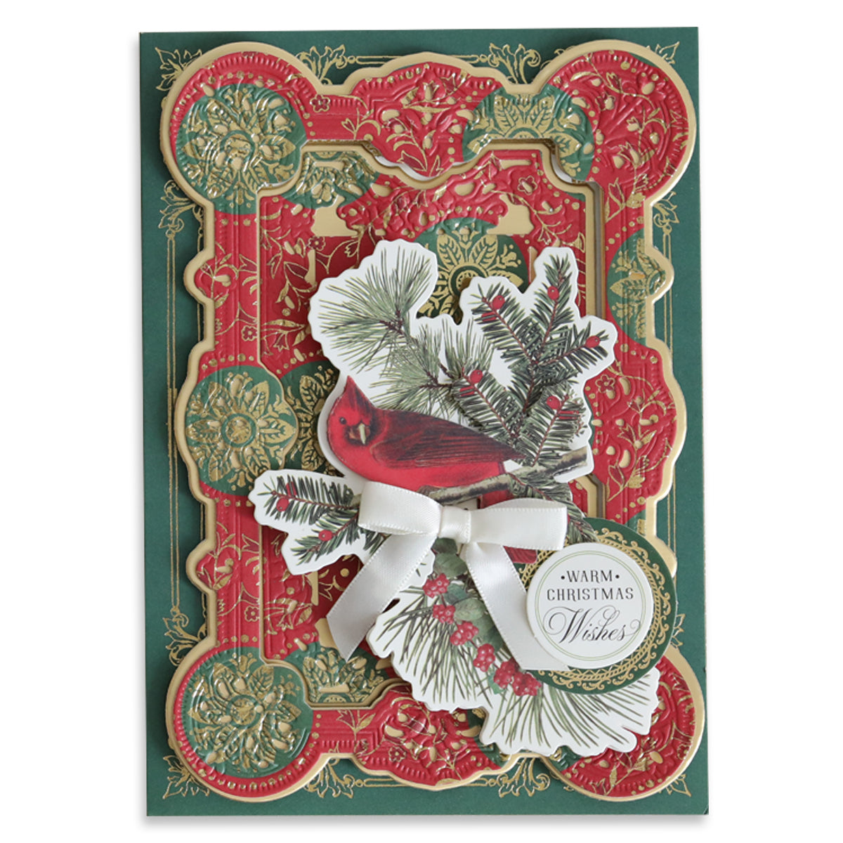 Introducing the Christmas Paper Anthology: a festive card embellished with detailed red and green patterns featuring a cardinal, pine branches, berries, a white bow, and a handmade holiday tag that reads "Warm Christmas Wishes.