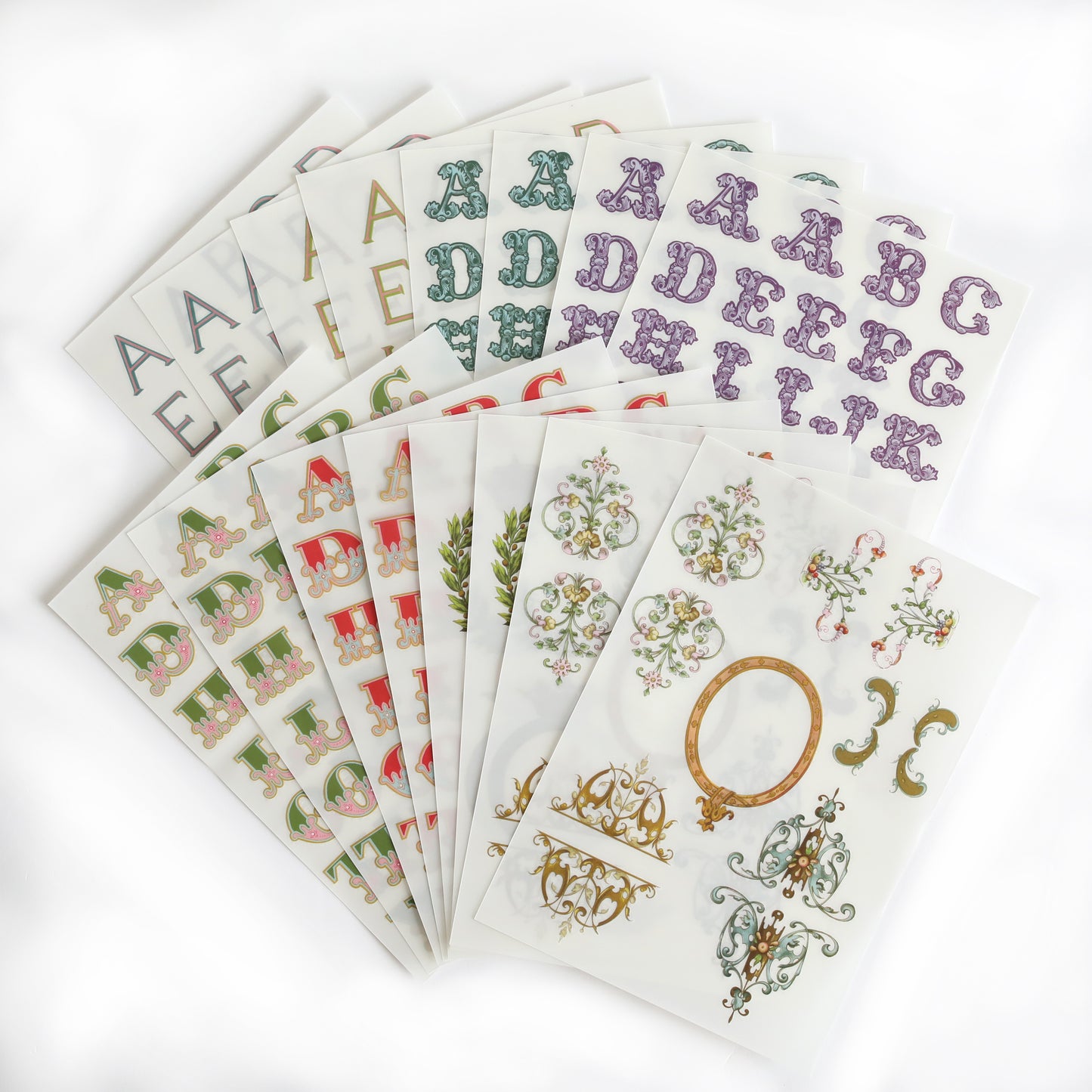 The Fancy Alphabet Rub On Transfers, ideal for scrapbooking or cardmaking, are fanned out on a white background.