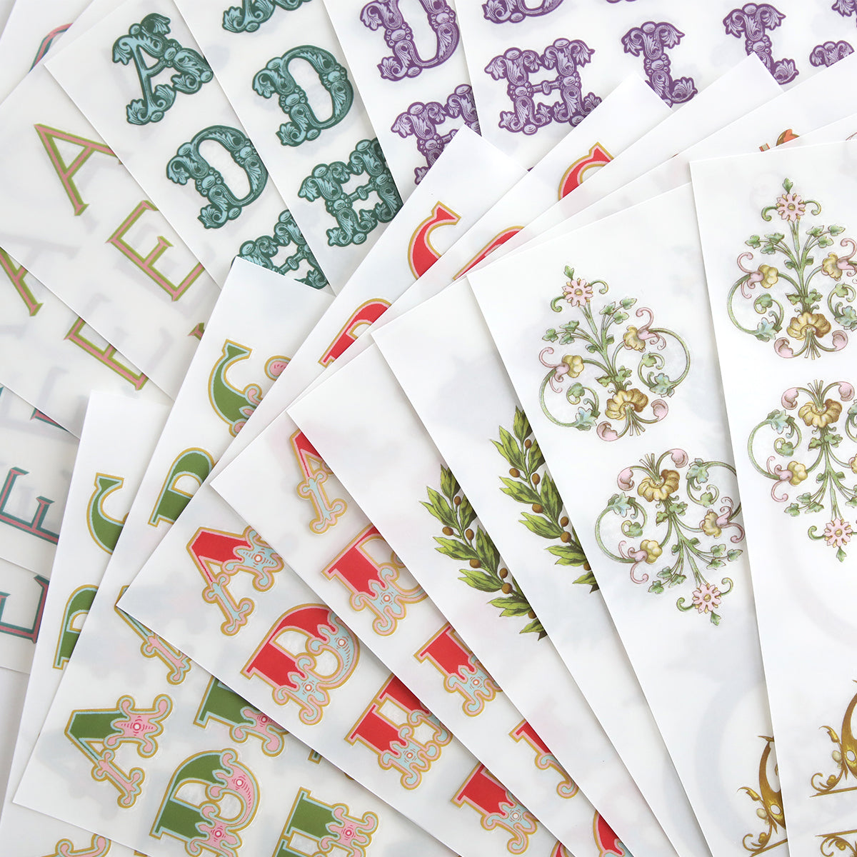 Fancy Alphabet Rub On Transfers feature ornate, floral designs in multiple colors and styles—ideal for cardmaking and scrapbooking projects.