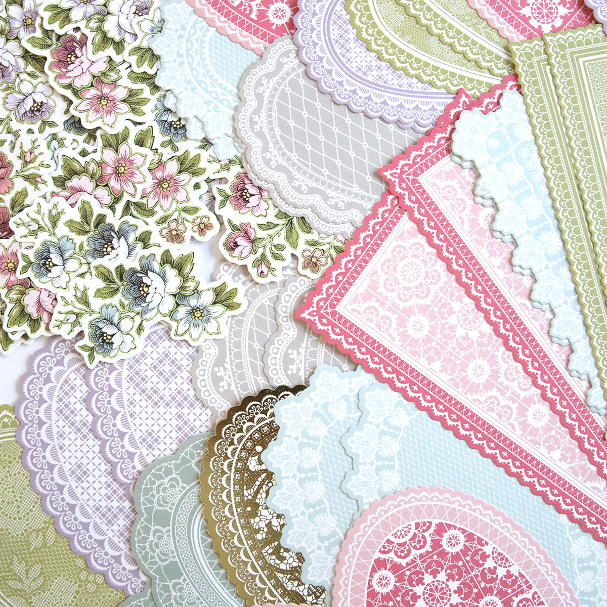 A vintage pile of papers with Lace Doily Embellishments and flowers, perfect for creating Valentine's cards or adding vintage diecut embellishments.