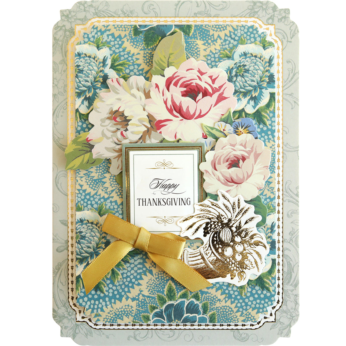 The Simply Thanksgiving Card Making Kit is perfect for crafting handmade cards with its decorative features, including a floral design with pink and white flowers, a gold ribbon, and an illustration of a cornucopia on a blue patterned background.