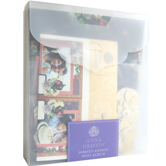 A translucent plastic folder holds the Simply Astrid Mini Album and Materials, featuring floral embellishments on a visible scrapbook page and family photos inside.