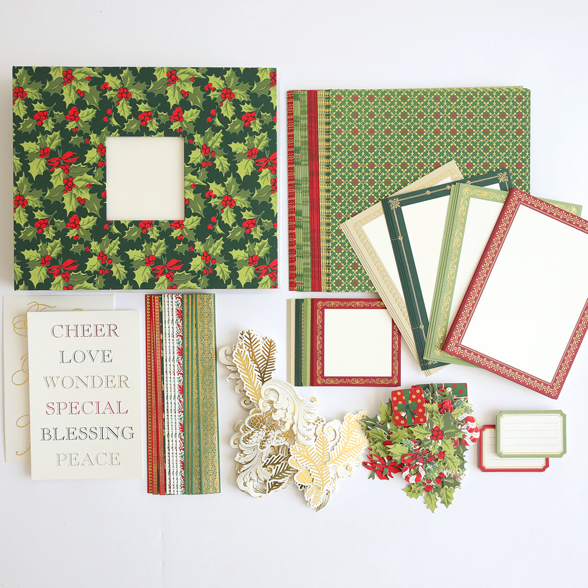The Simply Noel Mini Album and Materials features Christmas-themed supplies—decorative paper, card frames, gold accents, and word cutouts. Perfect for mini album projects or preserving holiday memories. Displayed on a white background.