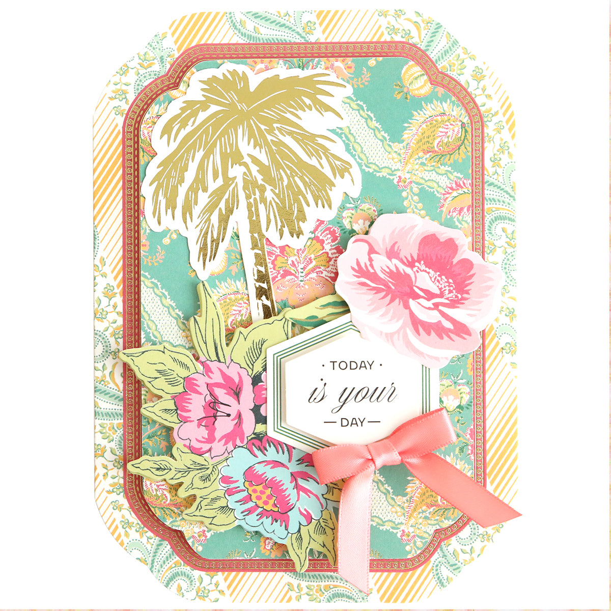 A decorative card from the Simply Tropical Card Making Kit features floral patterns, a palm tree illustration, 3D embellishments, "Today is your day" text, and a pink ribbon bow on a pastel background—perfect for handmade cards.