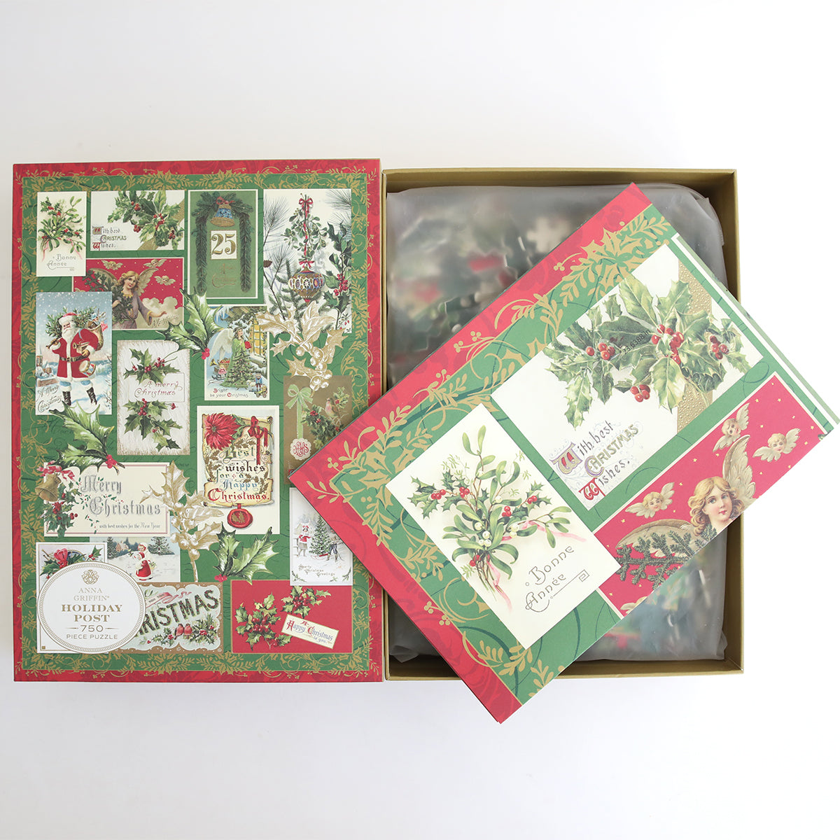 The Christmas Post Jigsaw Puzzle comes in a decorative holiday gift box featuring vintage Christmas-themed illustrations and postcards on the lid, partially open to reveal the puzzle pieces inside.