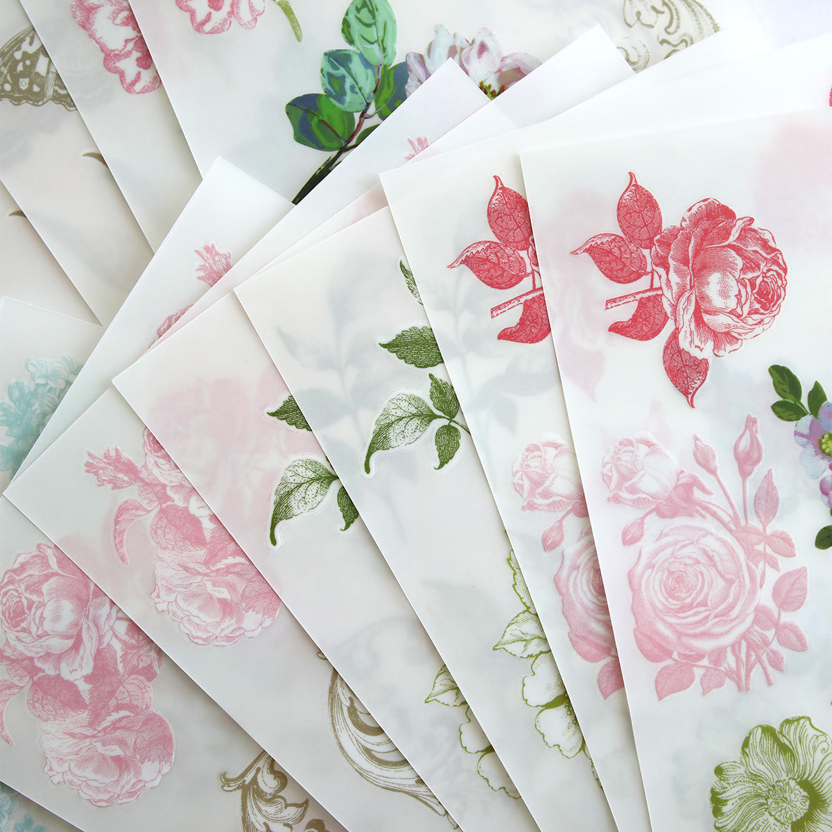 Antique Botanical Rub On Transfers feature translucent sheets with pink, green, and red floral designs—perfect for adding a vintage touch to scrapbook pages or crafts.