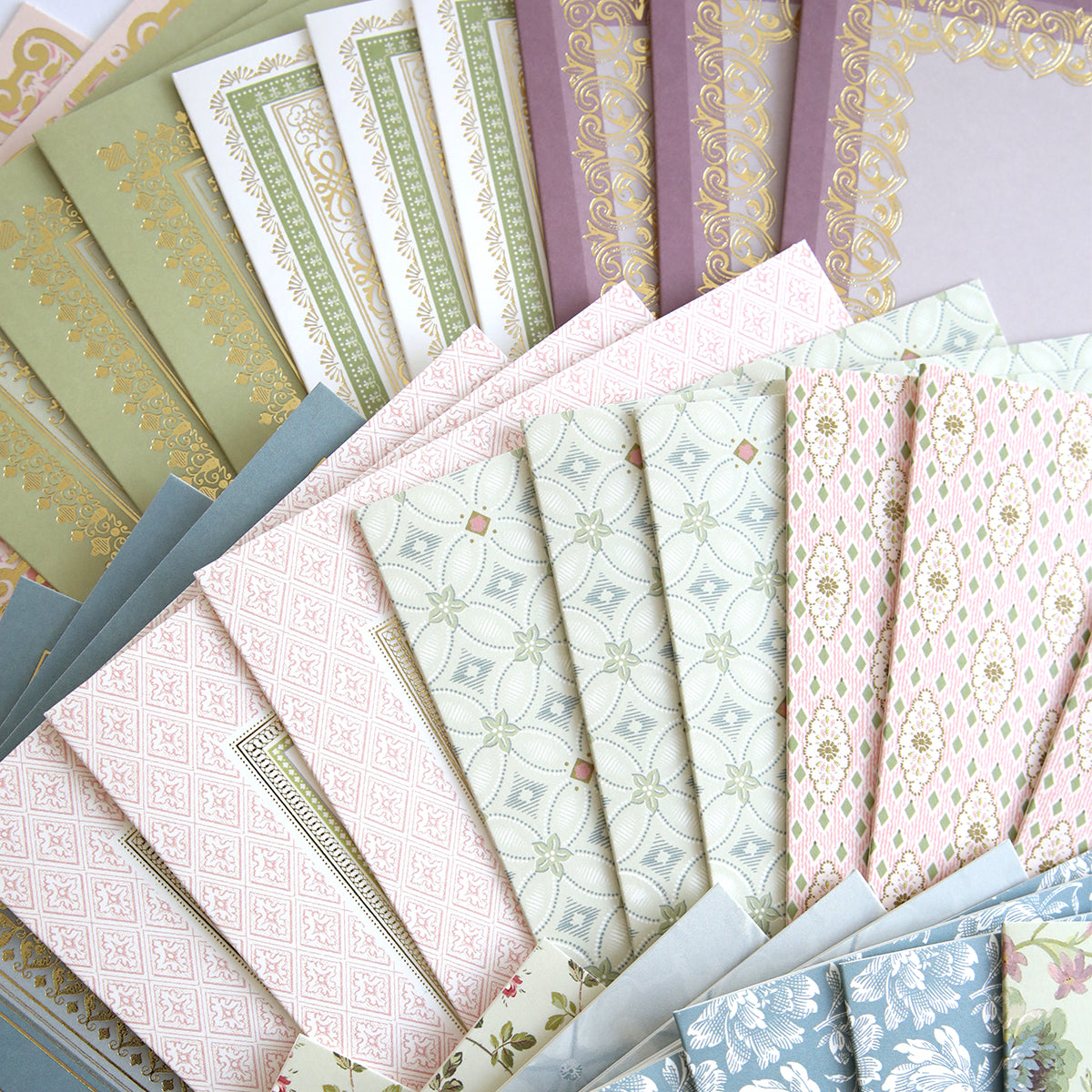 Francesca Cards and Envelopes are shown in a fanned-out display, featuring patterned and pastel-colored papers and envelopes—ideal for creating your next beautiful handmade card.