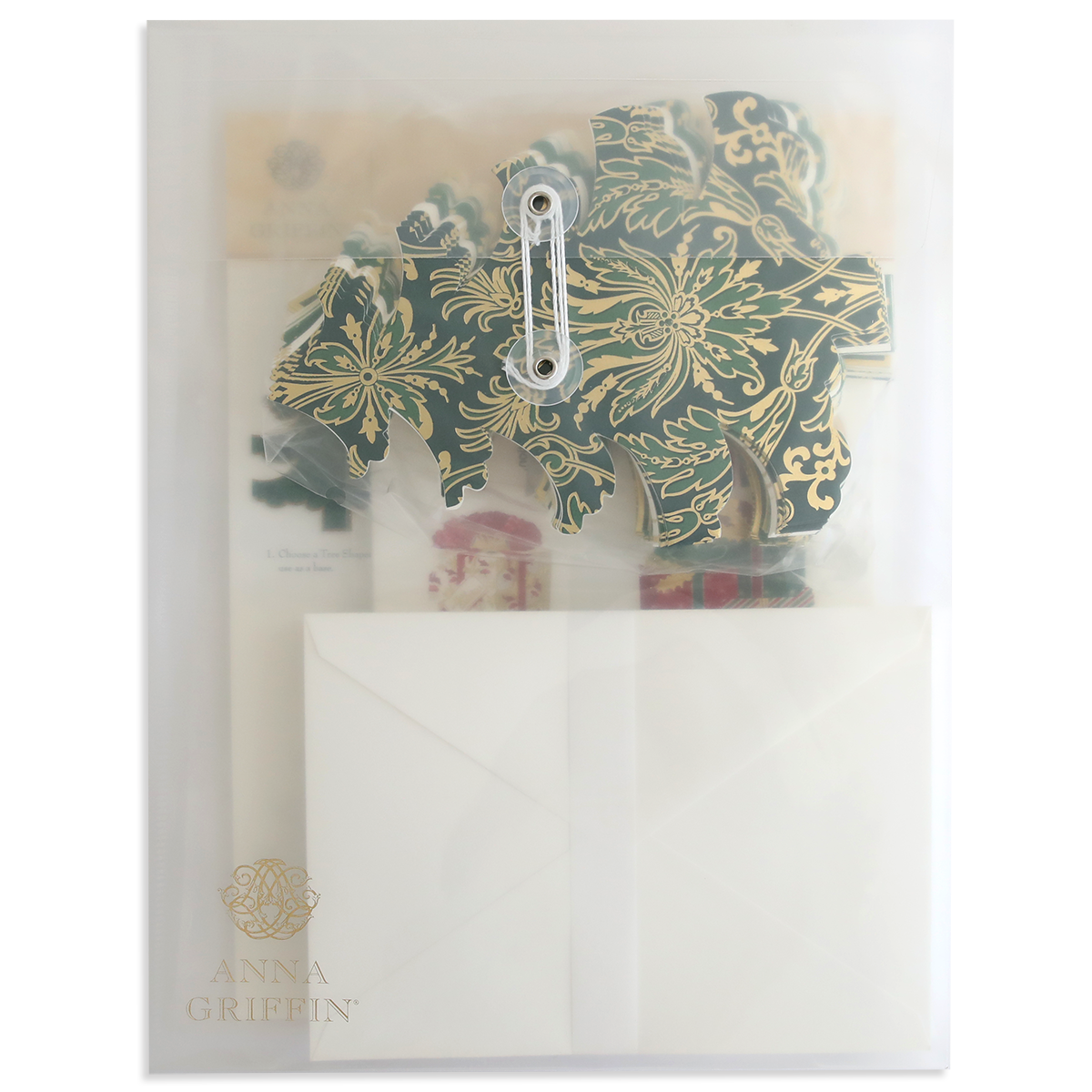 A transparent folder labeled "Tree Shaped Cards and Embellishments" contains decorative floral cutouts, Christmas tree embellishments, and a partially visible white envelope.