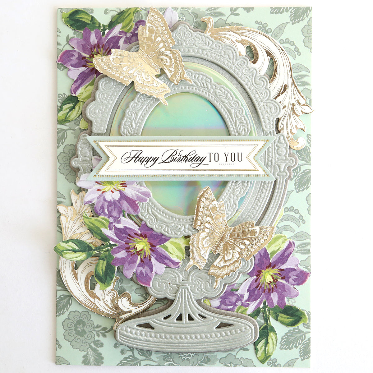 A decorative birthday card on Luxury Iridescent Foil Cardstock, adorned with gold butterflies, purple flowers, and a silver frame, featuring “Happy Birthday To You” on a central banner.