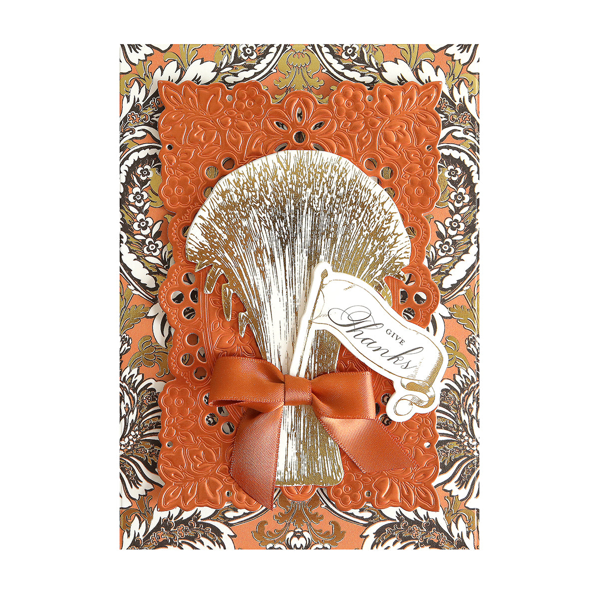 Greeting card features an ornate orange and gold design, metallic bow, and "Give Thanks" tag on a patterned background, crafted from Luxury Spellbound Foil Cardstock for an added touch of elegance.