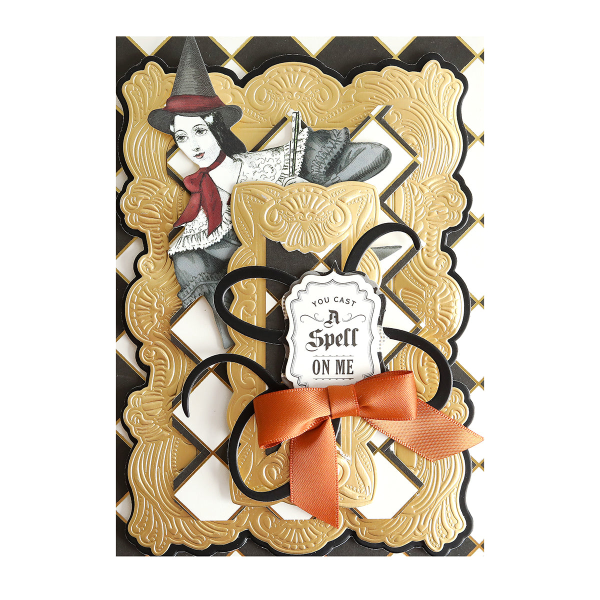 Greeting card with a vintage witch illustration, ornate gold and black frame on Luxury Spellbound Foil Cardstock, featuring a "You cast a spell on me" tag and finished with an orange ribbon bow.