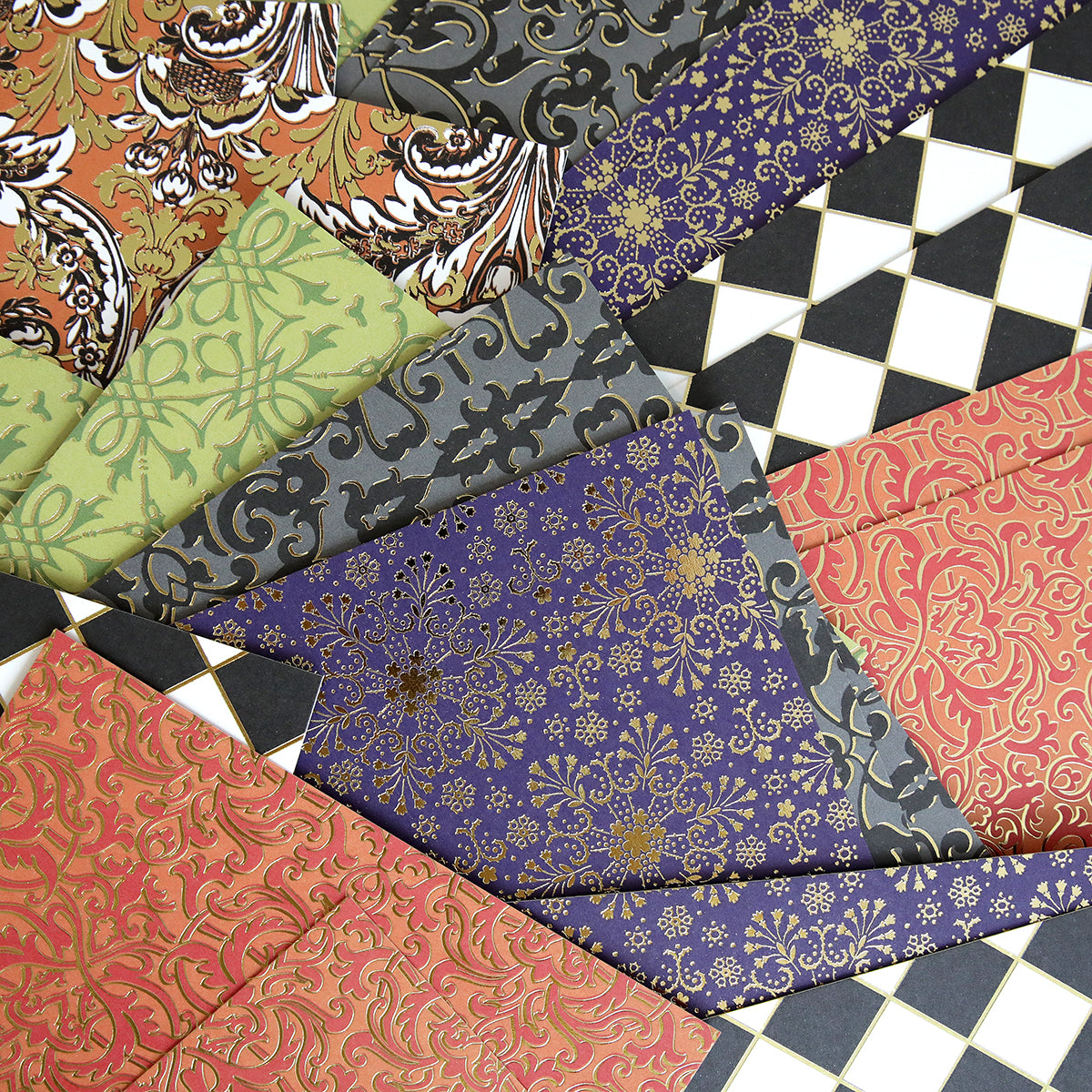 A fan-shaped display of Luxury Spellbound Foil Cardstock sheets featuring assorted colors with intricate floral and geometric designs.