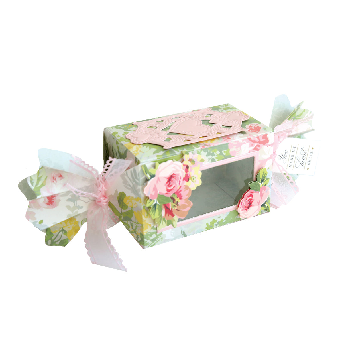 A floral favor box with a clear window, pink ribbon ends, and rose accents—perfect as a treat box crafted with the Candy Wrapper Box Dies.