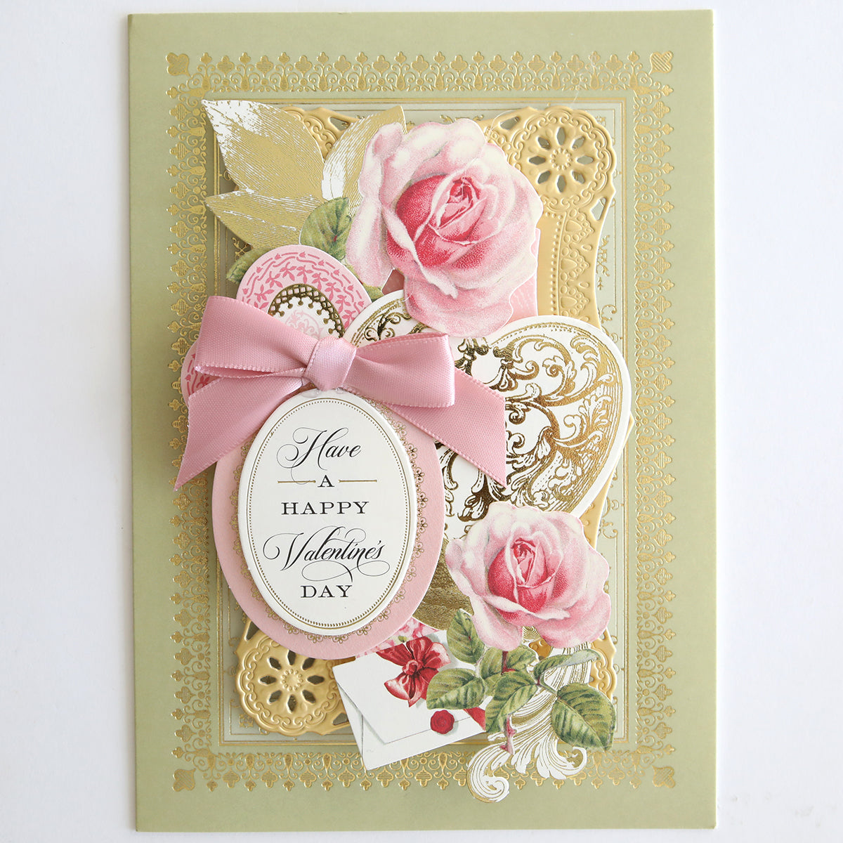 The Vintage Valentine Die Cut Embellishments decorate this Valentine’s Day card with pink roses, a pink bow, gold accents, and an oval label reading “Have a Happy Valentine’s Day” for a charming paper-crafted touch.