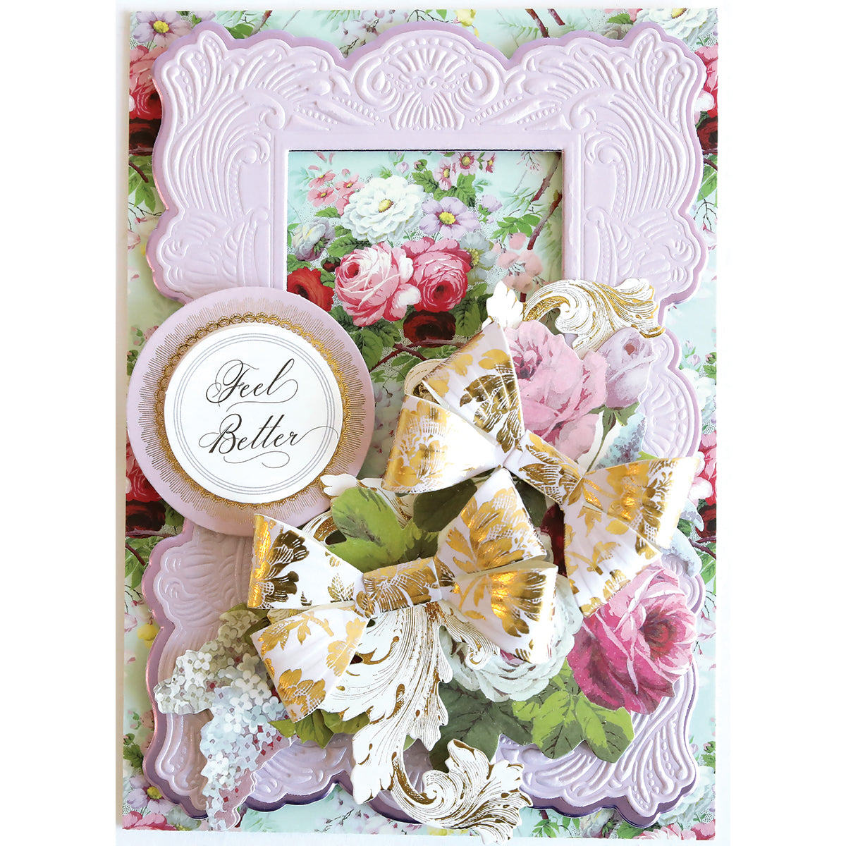 A decorative "Feel Better" card, great for card making, featuring a pink embossed frame, floral background, and gold-accented bows and leaves created with the Flowing Bow Die.