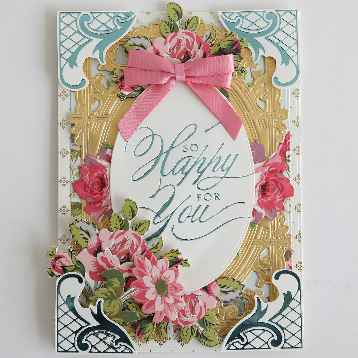 Crafted from Ivory Coated Cardstock, this decorative card features floral designs, gold accents, a pink ribbon, and "So Happy For You" in cursive at the center with elegant hot foil details.