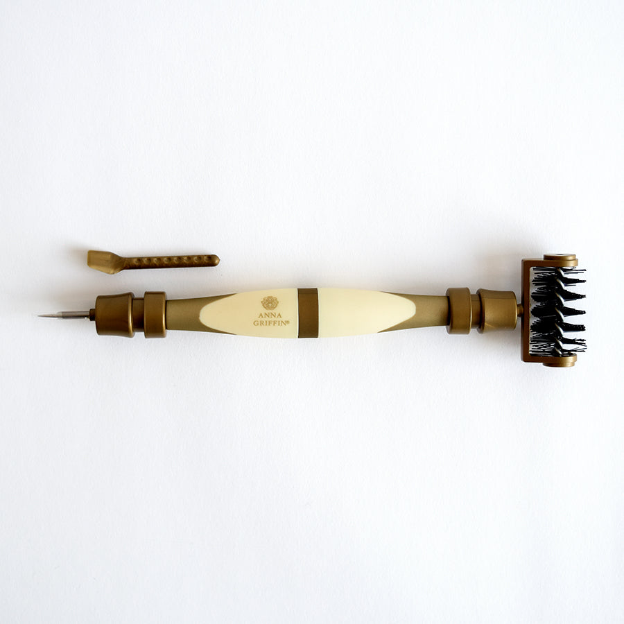 The Diecutting Essential Tools is a craft tool in brown and cream colors that features dual ends: one side has a pointed tip and the other side is equipped with a brush, making it ideal for diecutting and embossing projects.