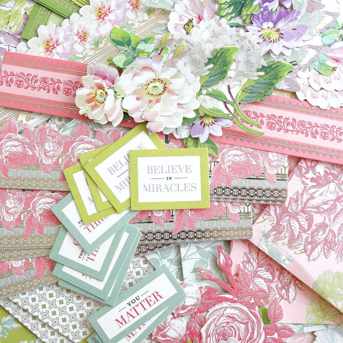 A collection of floral-patterned stationery and cards, featuring messages like "Believe in Miracles" and "You Matter," in shades of pink, green, and white.