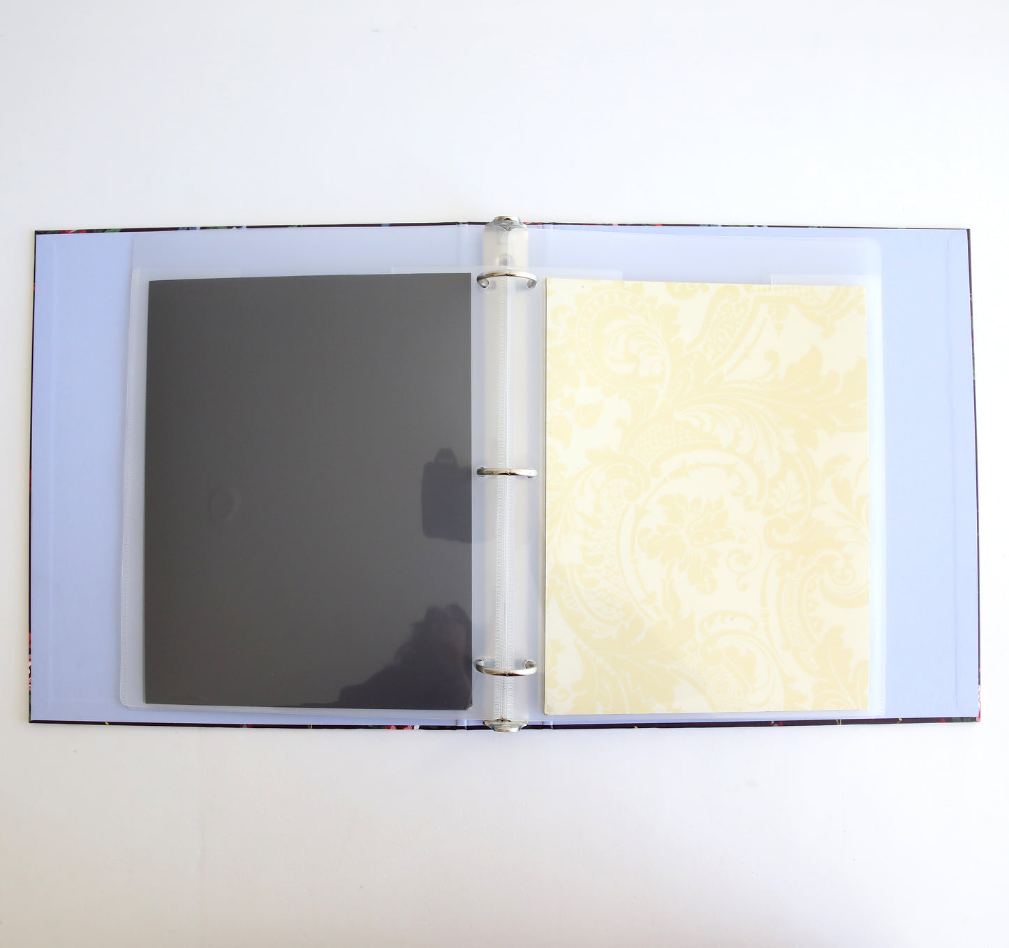 An open Astrid Floral Magnetic Die Storage Binder with one transparent sleeve and one patterned yellow page against a white background, perfect for crafting organization.
