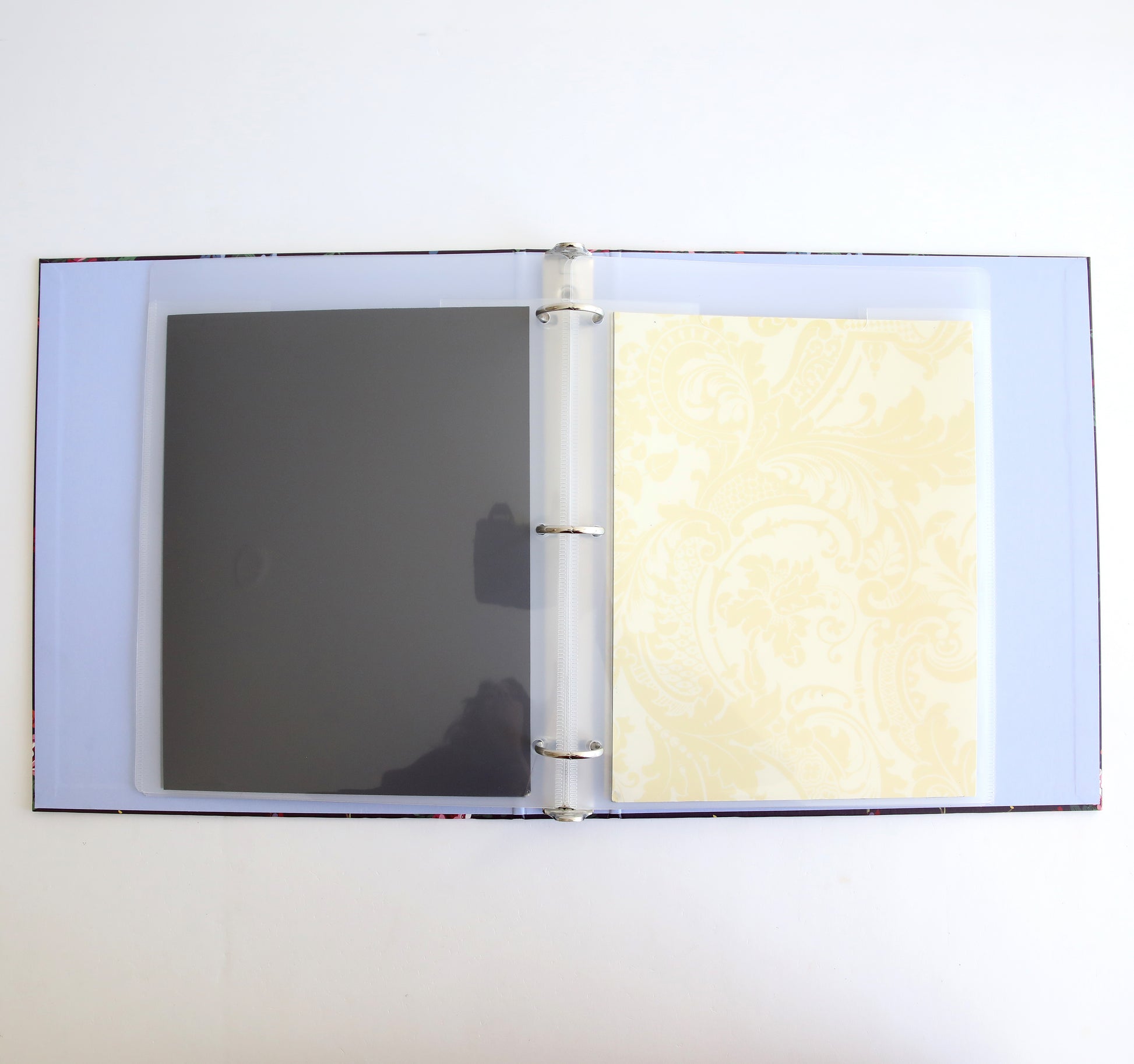 An open Astrid Floral Magnetic Die Storage Binder with one transparent sleeve and one patterned yellow page against a white background, perfect for crafting organization.
