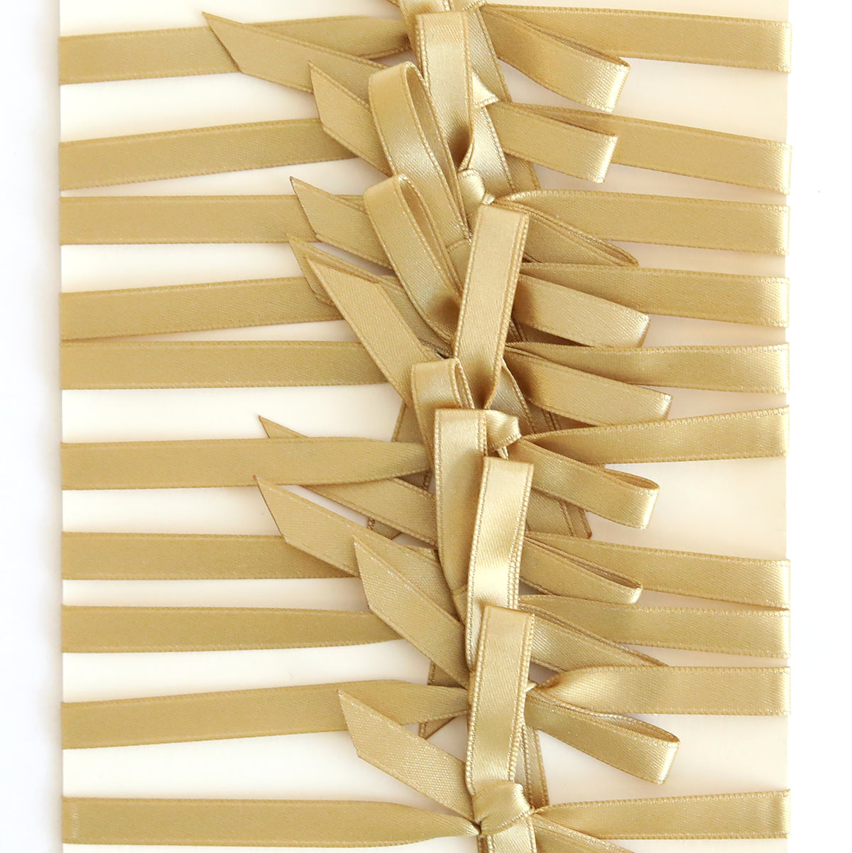 Gold Satin Bows 10 count features gold double-faced satin bows, pre-tied and arranged horizontally in an overlapping pattern on a white rectangular surface.