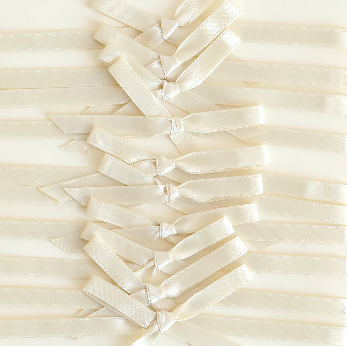 Neat crisscross patterns of satin bows, reminiscent of handmade cards, embellish a cream background in this Ivory Satin Bows 10 count set.