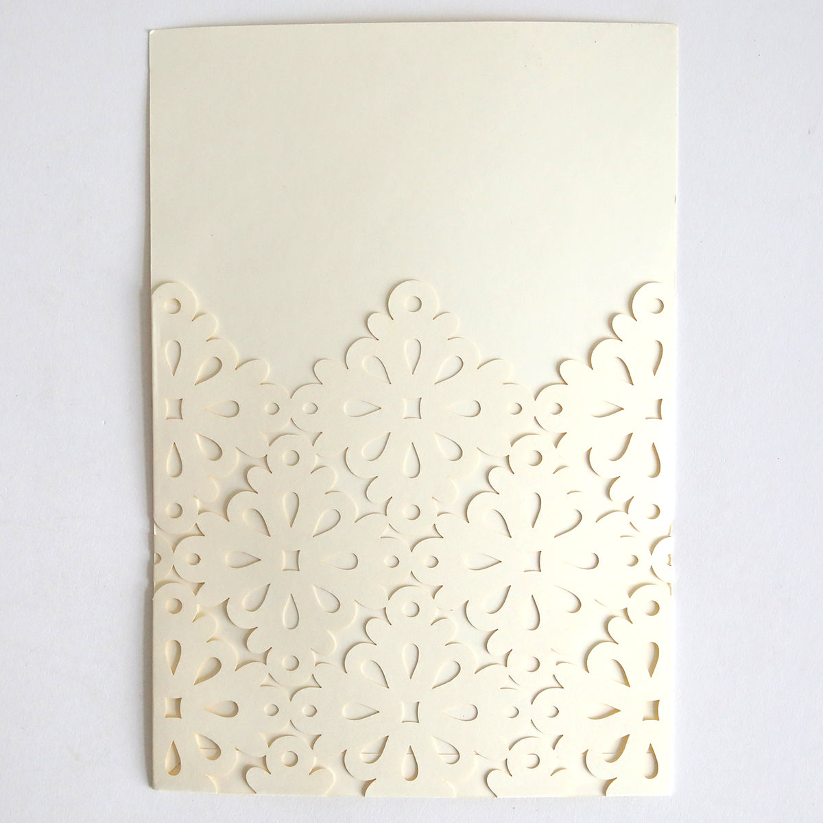 The Diecut Filigree Pocket 10 pack features cream-colored cards with an intricate symmetrical floral filigree on the lower half, set against a white background—ideal for creating elegant custom or wedding invitations.