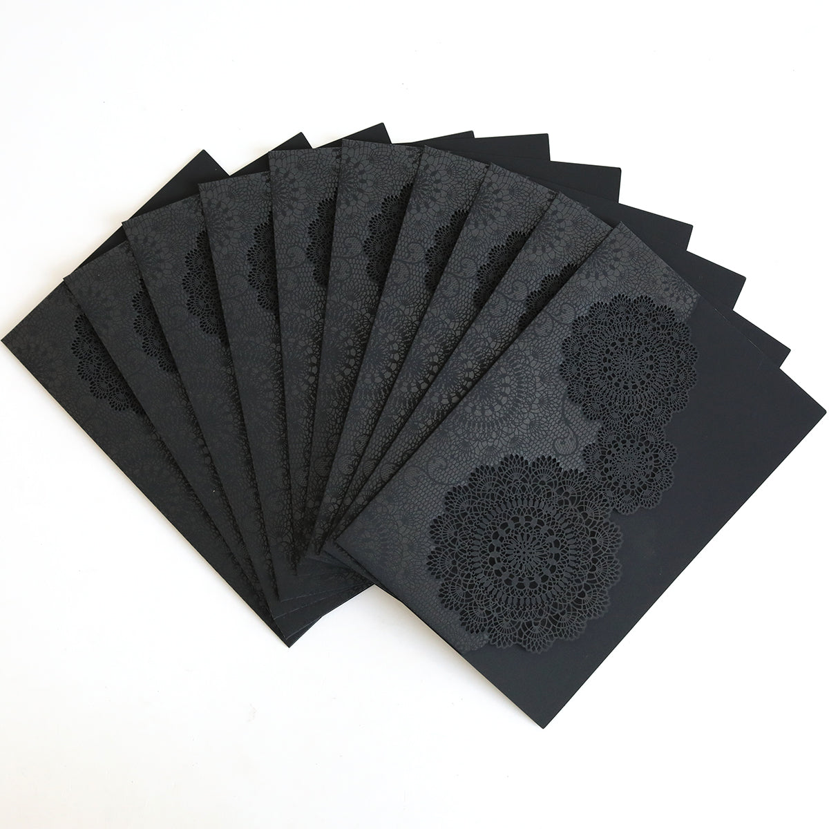 The Black Laser Cut Lace Pocket 10 pack features intricately patterned black pockets, perfect for elegant wedding invitations, all set against a white background.