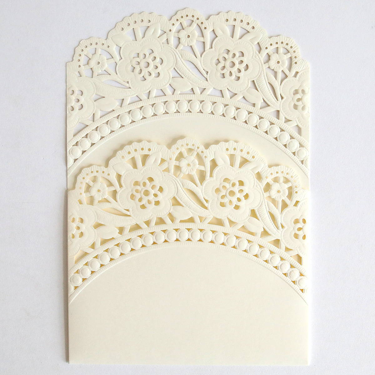 The Ivory Double Scallop Lace Pocket 10 pack features intricately laser-cut, cream-colored holders with scalloped edges and an arched design—ideal for elegantly presenting wedding invitations on a plain white background.