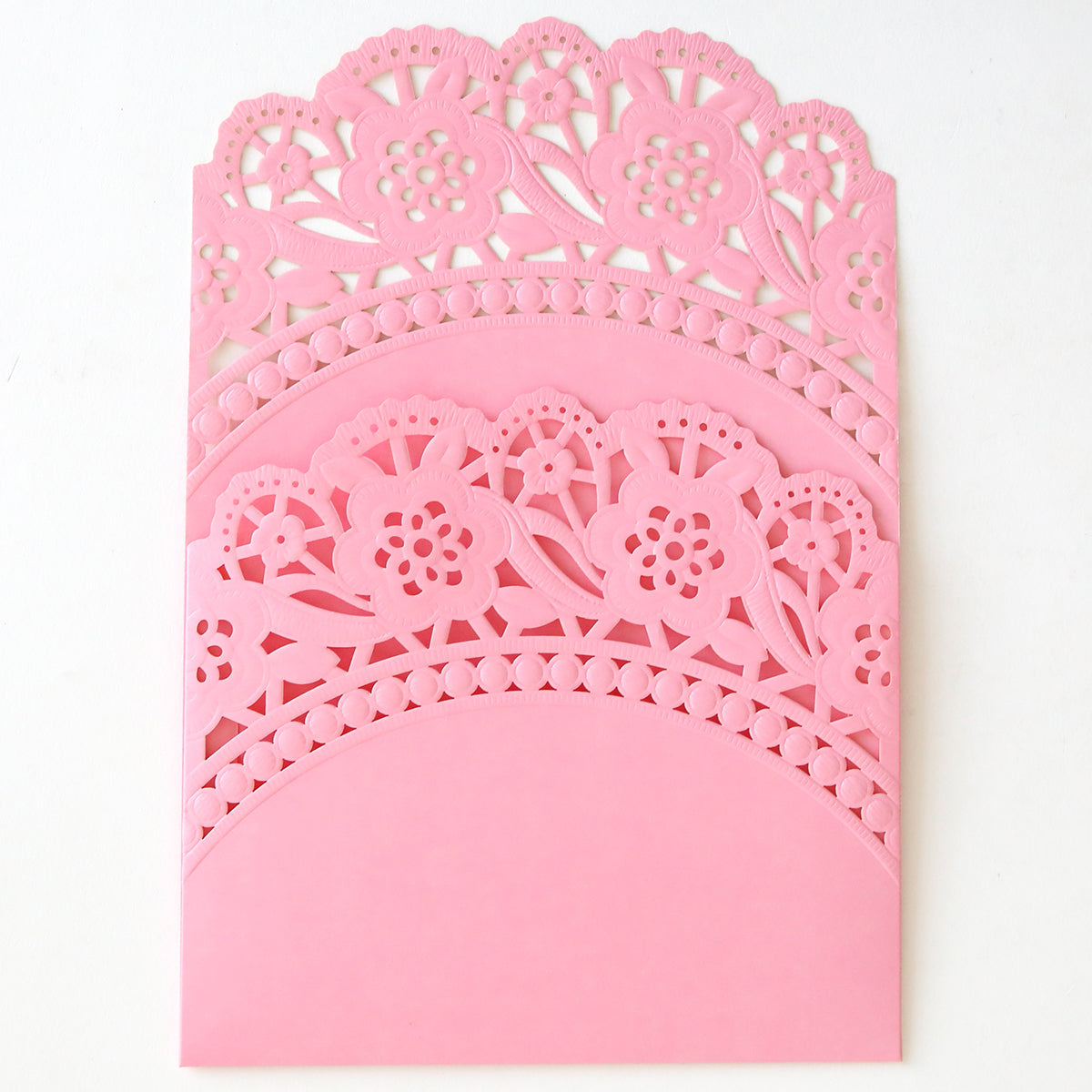 The Pink Double Scallop Lace Pocket 10 pack features pink envelopes with intricate floral laser-cut patterns and a double scallop edge—ideal for elegant wedding invitations. Shown here against a white background.