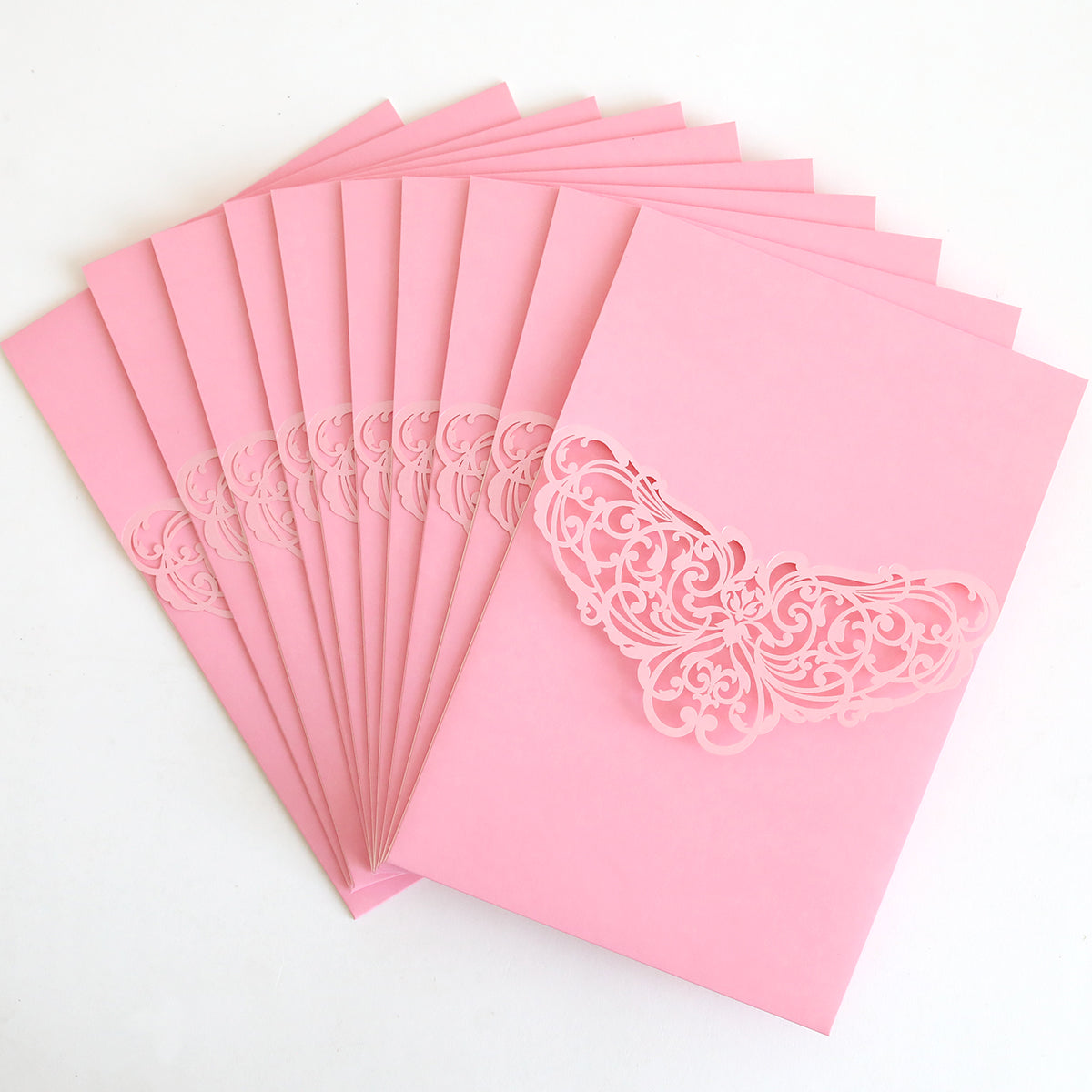 A pack of Pink Laser Foil Flap Pocket invitations is arranged in a fanned-out display on a white surface.