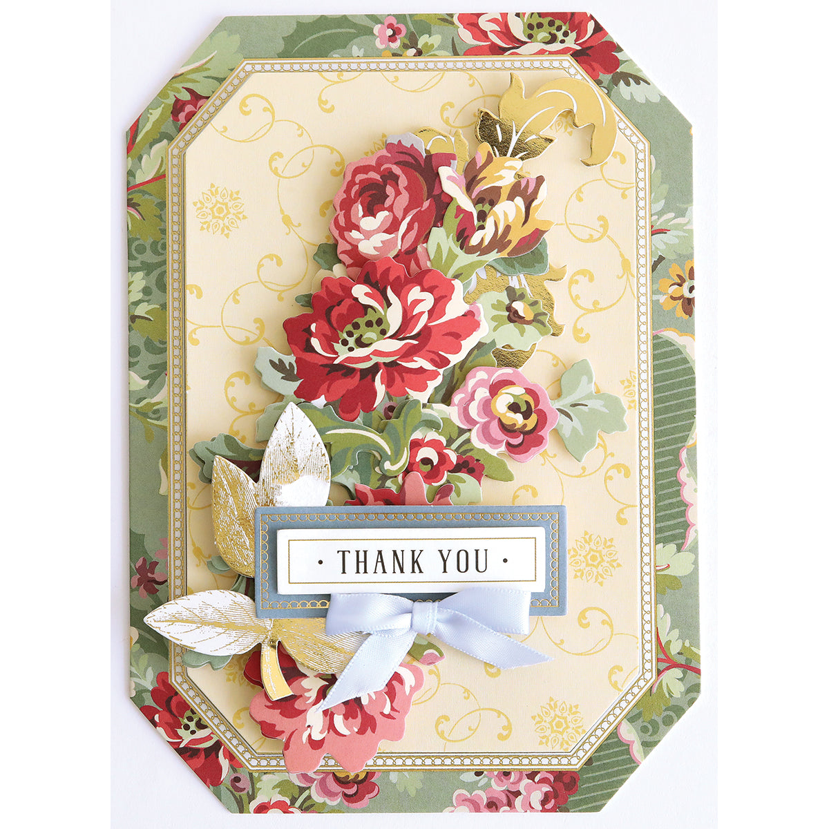 The Simply Gratitude Card Making Kit features a decorative thank you card adorned with red and gold flowers, green leaves, gold accents, and a blue ribbon, all framed by a floral patterned border—an ideal choice for handmade card enthusiasts or anyone seeking to enhance their gratitude card collection.