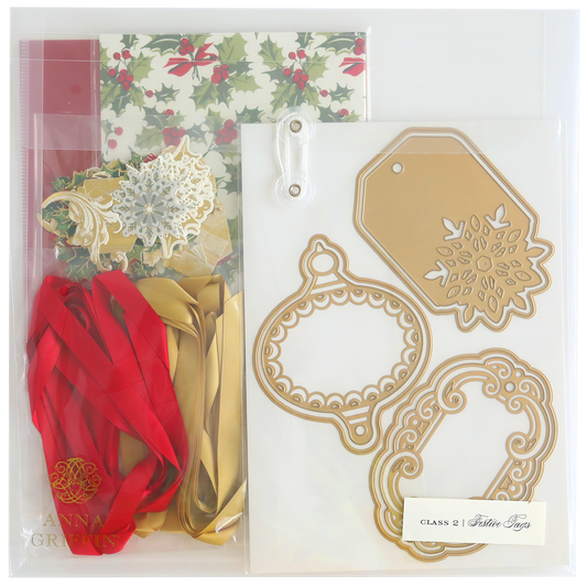 Festive Tags Dies and Materials kit includes holly-themed cardstock, satin red and gold ribbons, decorative cutout designs, and festive metallic tags.