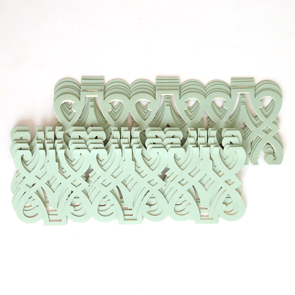 The Blue Grey Filigree Diecut Wrap 10 pack features a symmetrical design of interlocking, pale green decorative cut-outs on white, reminiscent of classic diecut wraps popular for elegant wedding invitations.