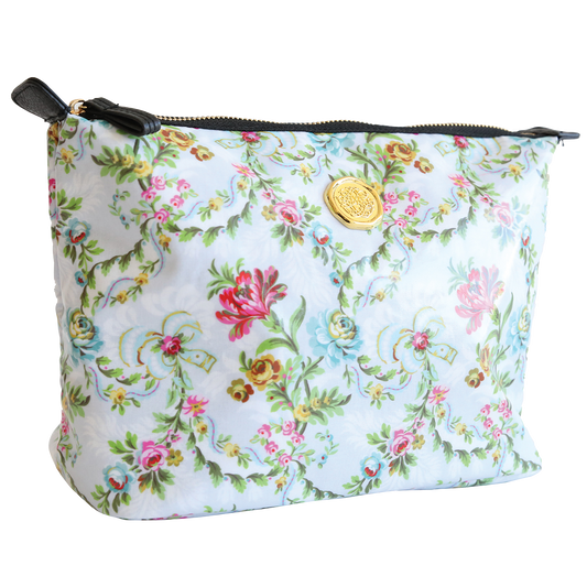 The Phoebe Large Cosmetic Bag showcases a floral print with a gold emblem on a white background and features a nylon interior. This spacious cosmetic bag measures 11″ x 7.5″ x 5.25″, offering ample room for all your essentials.