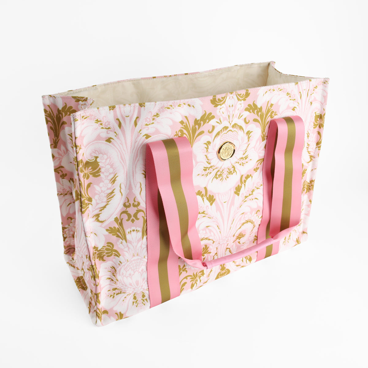 The Pink Damask Tote Bag features a rectangular design with a pink and gold floral pattern, complemented by wide pink and gold striped handles. Set against a white background, this elegant canvas tote is ideal for trips to the floral market or carrying your everyday essentials.