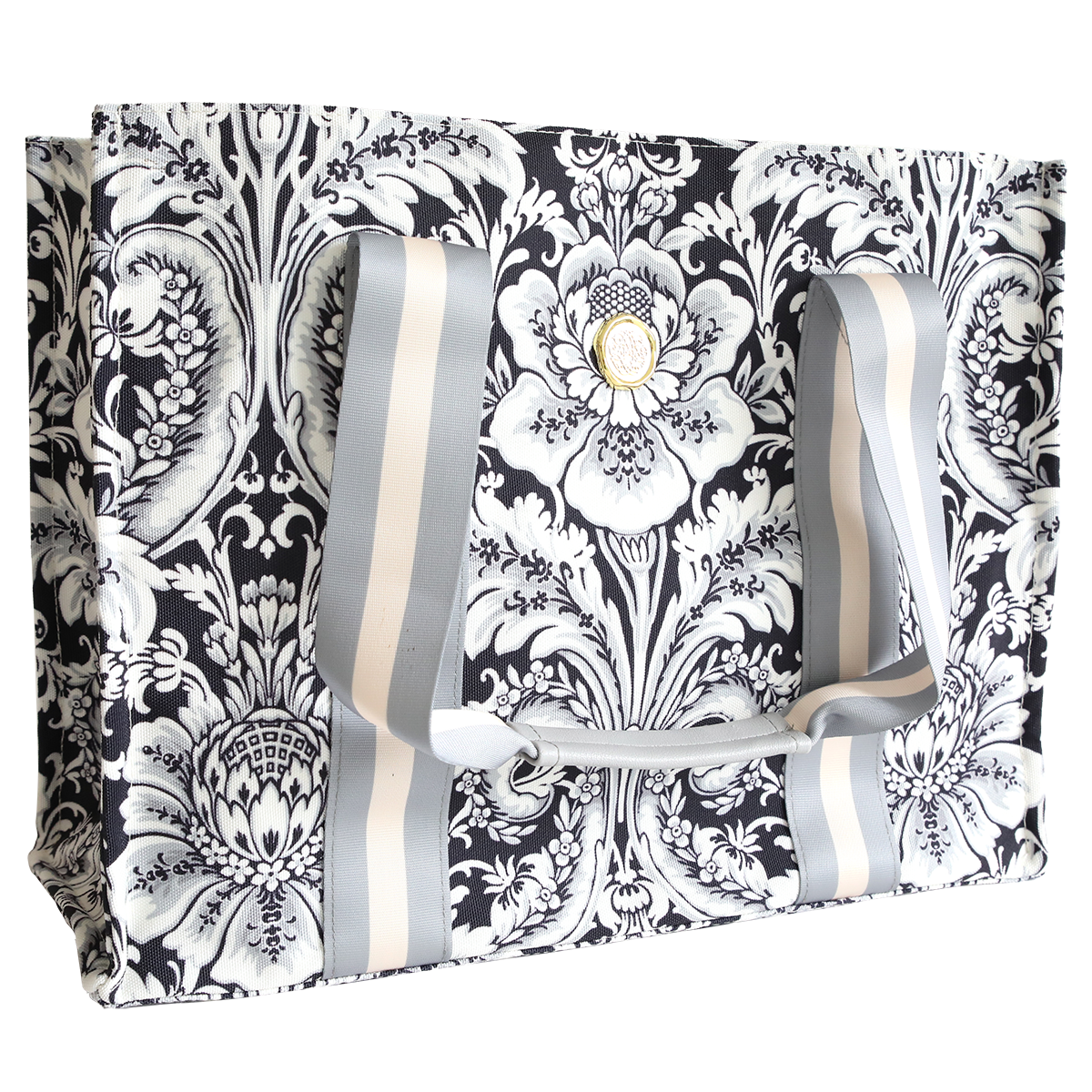 The Damask Noire Tote Bag features a black and white floral design, two wide gray and white striped handles, and is crafted from durable cotton for versatile everyday use.