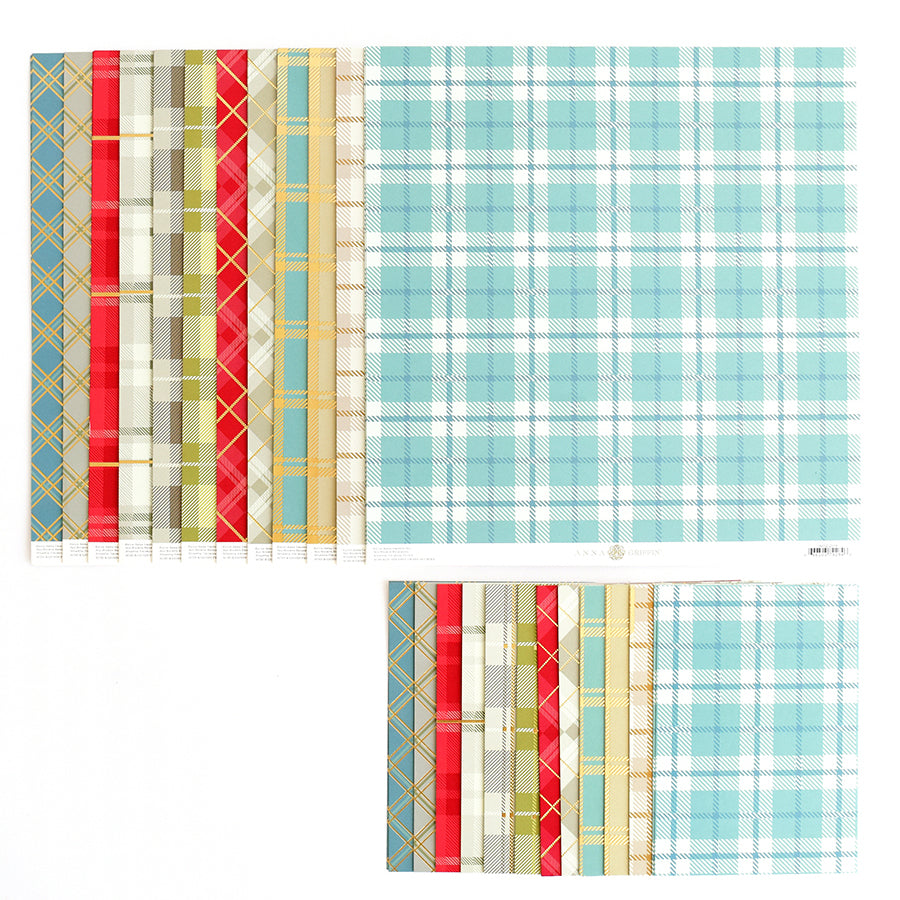 A selection of Fall Plaid 5x7 and 12x12 Cardstock, featuring patterns in light blue, red, and green, is artfully stacked in two piles against a white background—ideal for crafting and embracing fall trends.