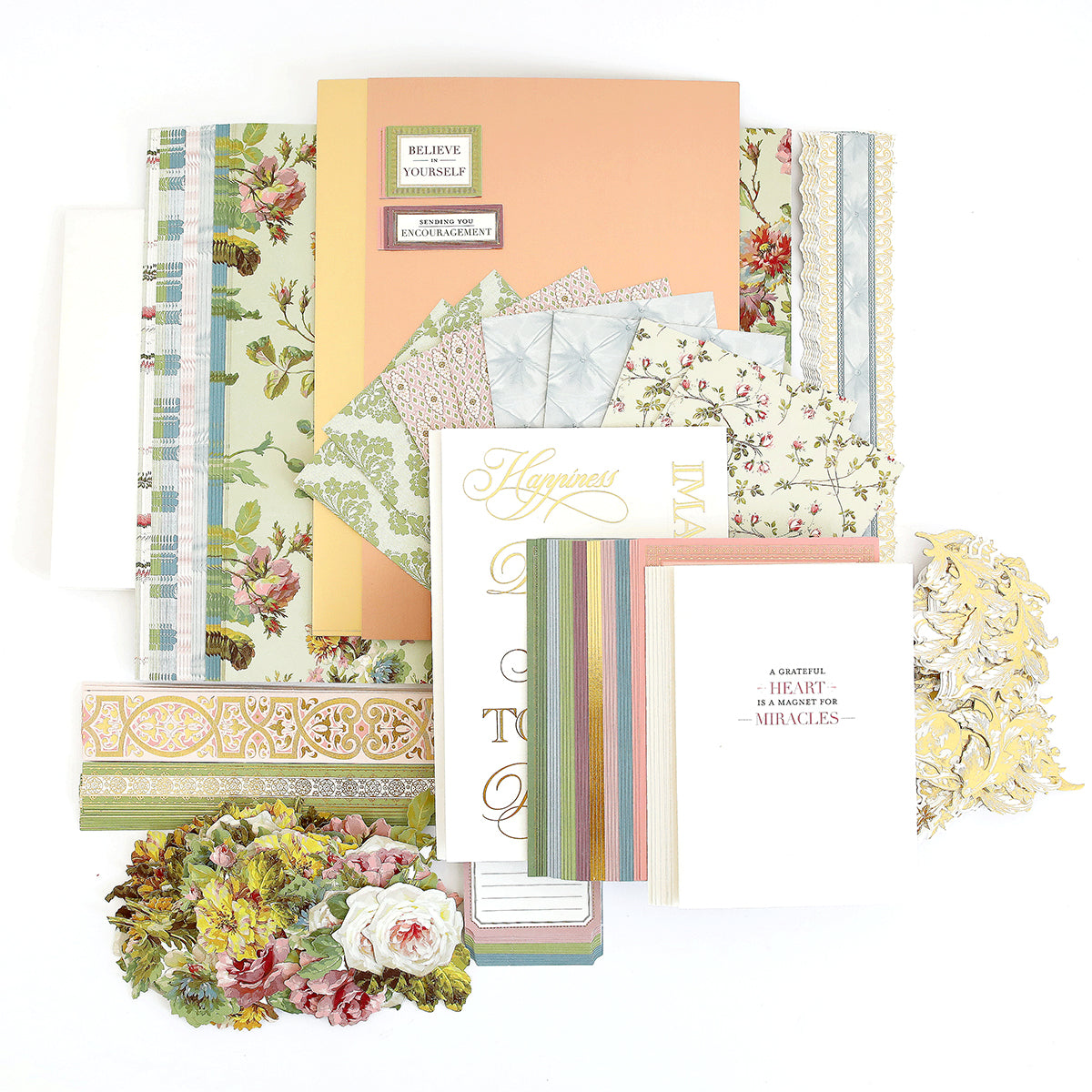 A collection of decorative patterned paper and cards, featuring floral designs, stripes, and inspirational text, displayed on a light background.