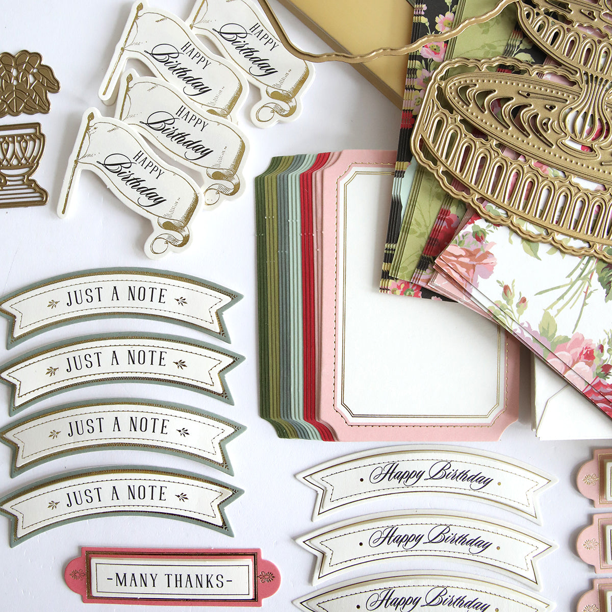 A collection of interactive cards and other items, including Anna Griffin's Garden Fountain Easel Finishing School Kit, displayed on a table.