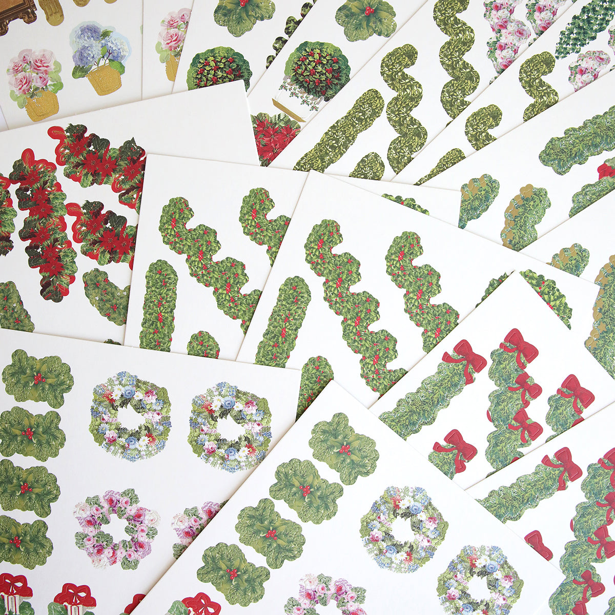 Garland Staircase Die Cut Stickers, featuring wreaths, plants, and bows, are spread out in a fan-like display—perfect for adding unique embellishments to your scrapbook projects.